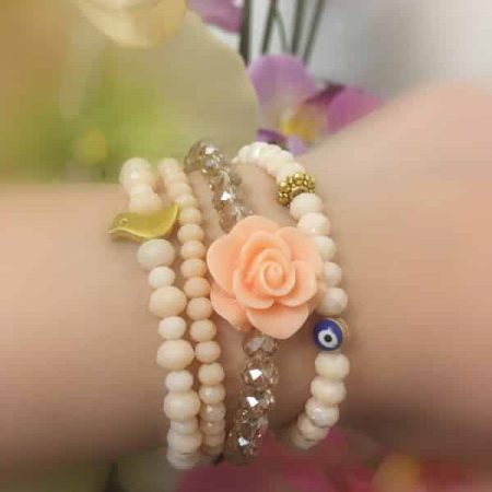 ست دستبند چهارتايي کریستالی با گل فومي و مهره چشم نظر و مرغ آمين و رنگ گلبهي روشن از نمای کنار